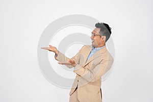 A handsome Asian businessman is opening his palms aside at an empty space on an isolated background