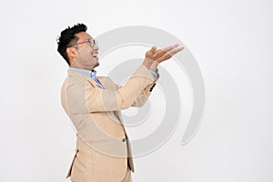 A handsome Asian businessman is opening his palms aside at an empty space on an isolated background