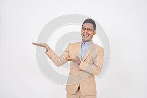 A handsome Asian businessman is opening his palms aside at an empty space on an isolated background