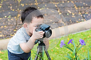 Handsome Asian kid take a photo by DSLR camera