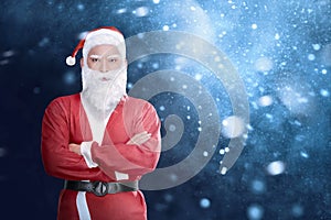 Handsome asian man in Santa Claus costume with crossed arms