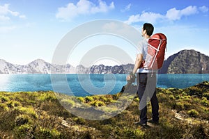 Handsome asian photograper man with backpack and camera photo