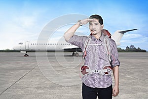 Handsome asian traveler man with backpack looking around