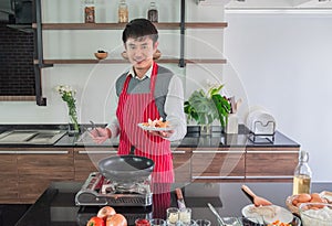 Handsome, Asian young man Smiling happiness. Holding fried sausage on dishes