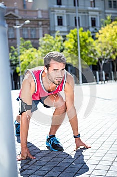 Handsome athlete in running stance