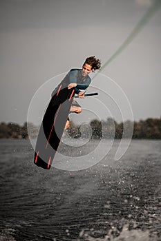 handsome athletic man doing an extreme jump on wakeboard