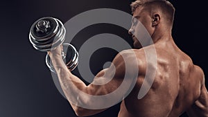 Handsome athletic man working out with dumbbells
