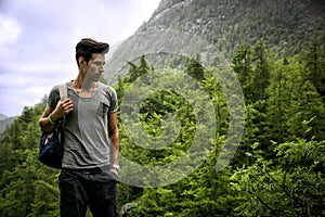 Handsome athletic young man with backpack in mountains