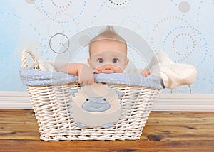 Handsome baby boy peeking out of wicker basket