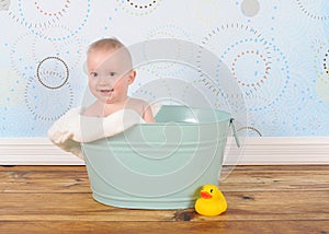 Handsome baby boy sitting in washtub