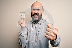 Handsome bald man with beard holding reminder paper with negative message annoyed and frustrated shouting with anger, crazy and