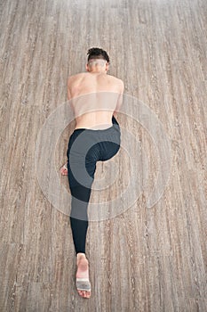 Handsome ballet dancer sitting on a splits