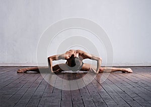 Handsome ballet dancer sitting on splits