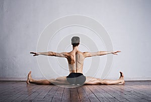 Handsome ballet dancer sitting on splits
