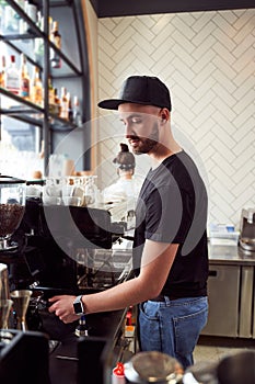 Male barista working on coffee machine photo