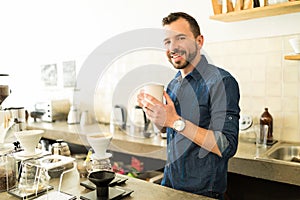 Handsome barista with a cup of coffee