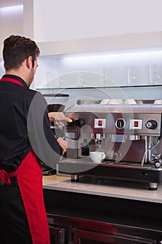 Handsome barista making a cup of coffee