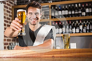 Handsome barman holding a pint of beer