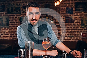 Handsome bartender preparing cocktail. Close up of bartender details with cocktails and bartending tools