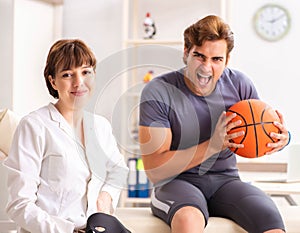Handsome basketball player visiting female doctor traumatologist