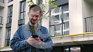 Handsome bearded caucasian man using mobile Phone. Young man texting Messages, cheating on his Smartphone in Office