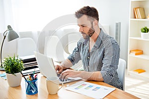 Handsome bearded concentrated businessman work on laptop photo