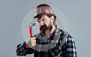 handsome bearded guy with beard and moustache hold hammer, building