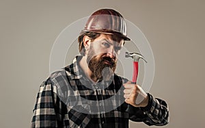 handsome bearded guy with beard and moustache hold hammer, building