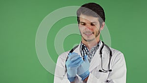 Handsome bearded male doctor putting on medical rubber gloves