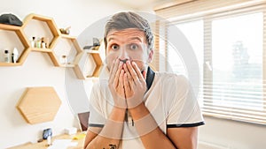 Handsome bearded man with facial expression laughing holding his hand on mouth