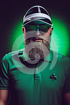 handsome bearded man in green polo shirt with shamrock