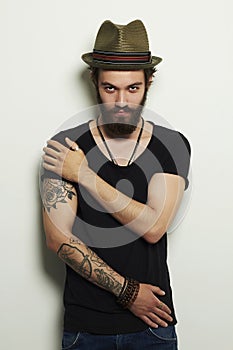 Handsome bearded man in hat.Brutal boy with tattoo