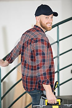 handsome bearded man holding toolbox