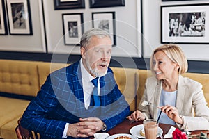 Handsome bearded man looking at the camera while his wife giving him dessert