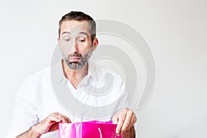 Handsome bearded man looking in a giftbag