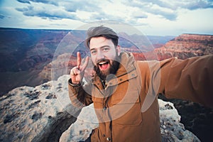 Handsome bearded man makes selfie photo on travel hiking at Grand Canyon in Arizona