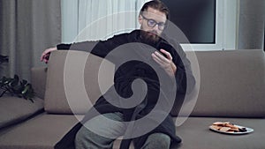 Handsome bearded man relaxing on sofa