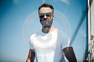 Handsome bearded man standing on a yacht