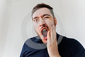 Handsome bearded man suffering from toothache, closeup,