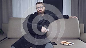 Handsome bearded man watching tv