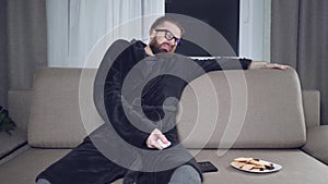 Handsome bearded man watching tv