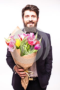 Handsome bearded man wearing in suit, with beard and nice bouquet of flowers