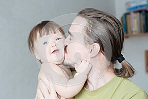 Handsome bearded young man kissing infant little girl. Happy smiling father and baby daughter portrait