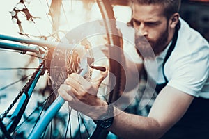 Handsome Bike Mechanic Repair Bicycle in Workshop