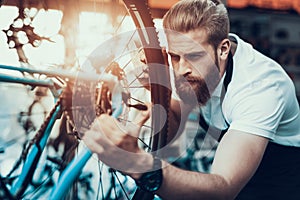 Handsome Bike Mechanic Repair Bicycle in Workshop