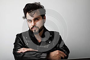 Handsome biker man wearing leather jacker posing over white background. Space for text.