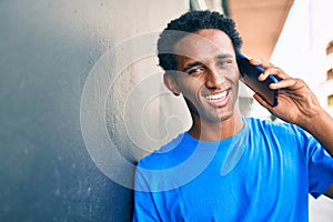 Handsome black african man smiling happy outdoors speaking on the phone