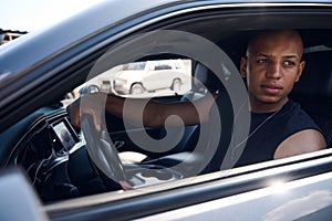 Handsome black driver trying to find some empty lot on parking