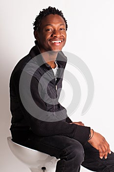 Handsome black guy sitting on a chair