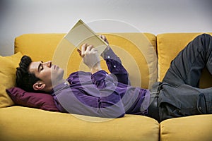 Handsome black haired young man reading book at